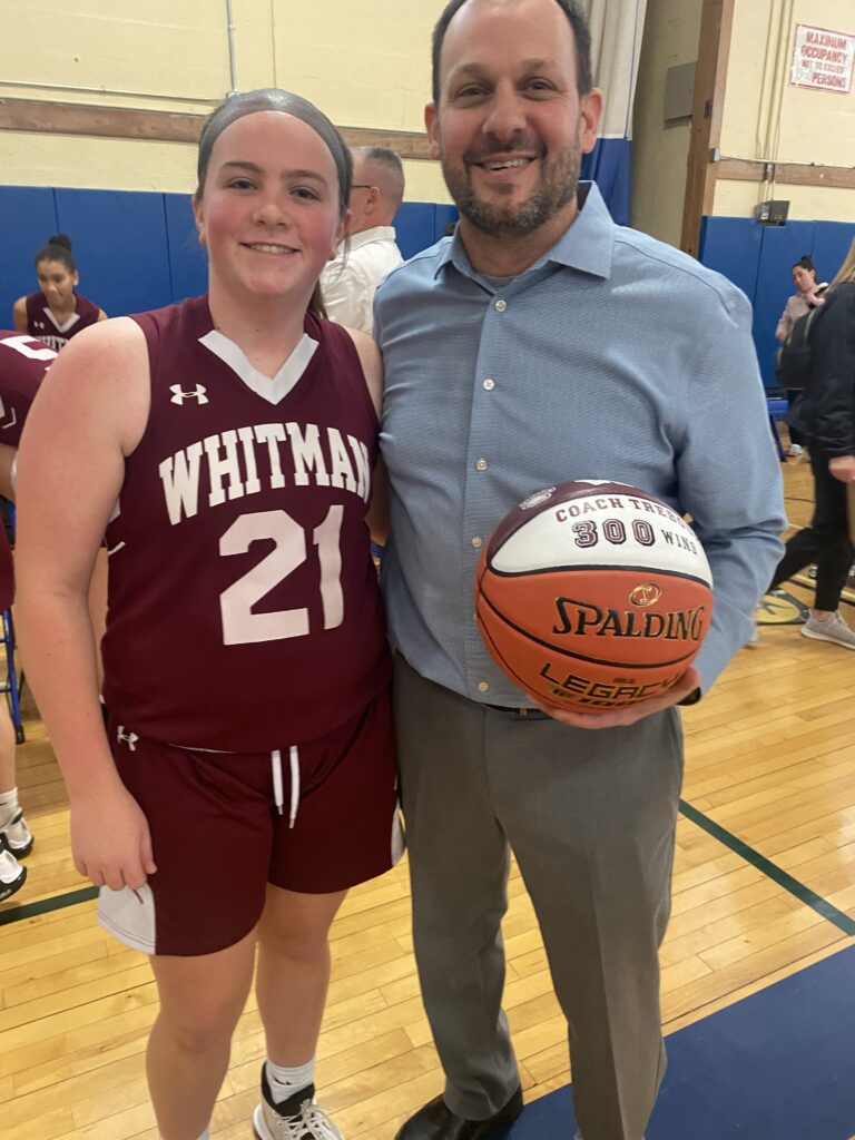 Iris Hoffman (left) is now a junior on Coach Trebour's (right) Wildcats Varsity Basketball Team at Walt Whitman High School. Coach Trebour is holding his 300th win basketball in his left hand