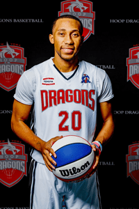 Willie Petro Jr wearing a white Dragons basketball jersey and holding a Wilson basketball