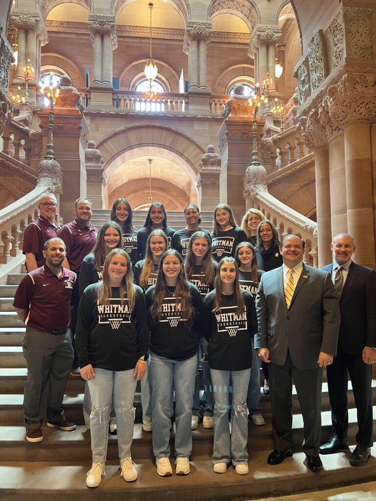 Coaches Mike Moccia, Dan Trebour, and Ralph Malazzo with the 2024 Long Island Champion Varsity Wildcats at the NYS Assembly. In the bottom right are Suffolk County District Attorney Raymond Tierney and New York Assemblyman Steve Stern.